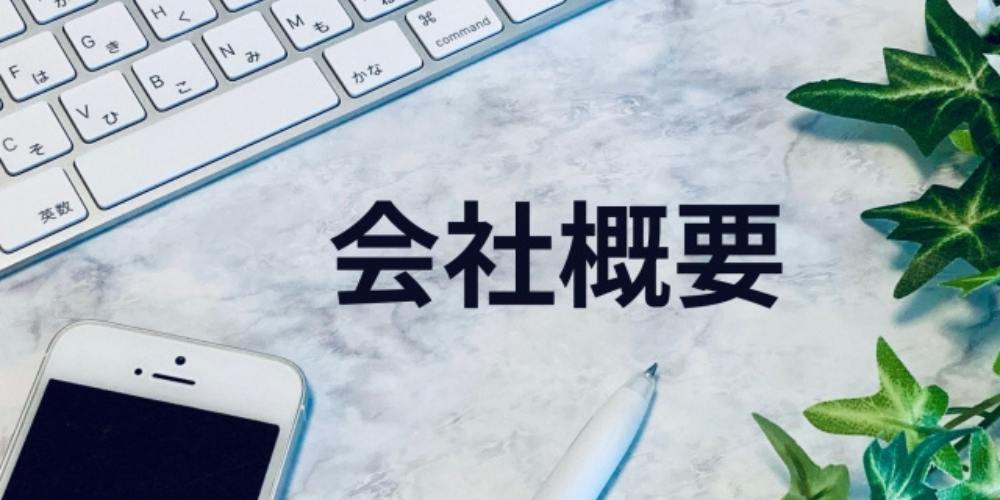 白い大理石のデスクにキーボードとスマートフォン、ペン、観葉植物が並び、「会社概要」と書かれている画像