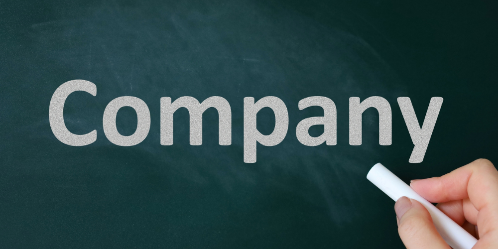 黒板のような深緑背景にチョーク風の大きな文字で「Company」と書かれ、右下でチョークを持つ手が強調されている
