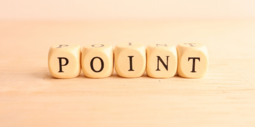 木製のサイコロにアルファベットで「POINT」と並べられているシンプルな構図。