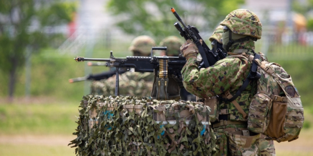 迷彩服を着た自衛隊員が銃を構えて訓練している様子