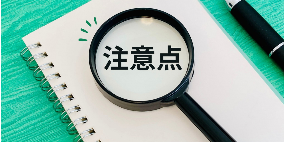 「注意点」の文字が虫眼鏡の中に拡大されて見えるノートの上の構図