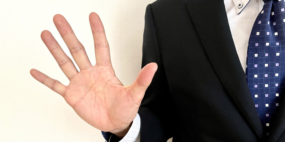 スーツ姿の男性が手を広げて5本の指を見せている様子