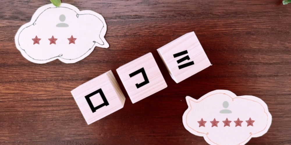 木目の背景に「クチコミ」と書かれたブロックと、星の数で評価された吹き出しが並べられている