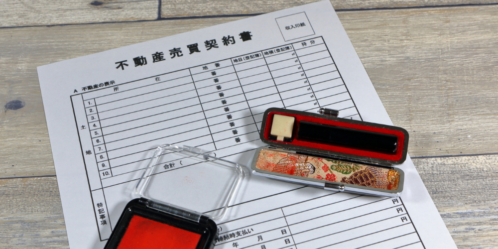 不動産売買契約書と印鑑セットが置かれた場面