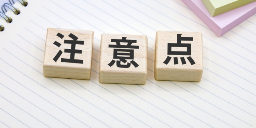 ノートの上に置かれたブロックに「注意点」の漢字が書かれている写真。