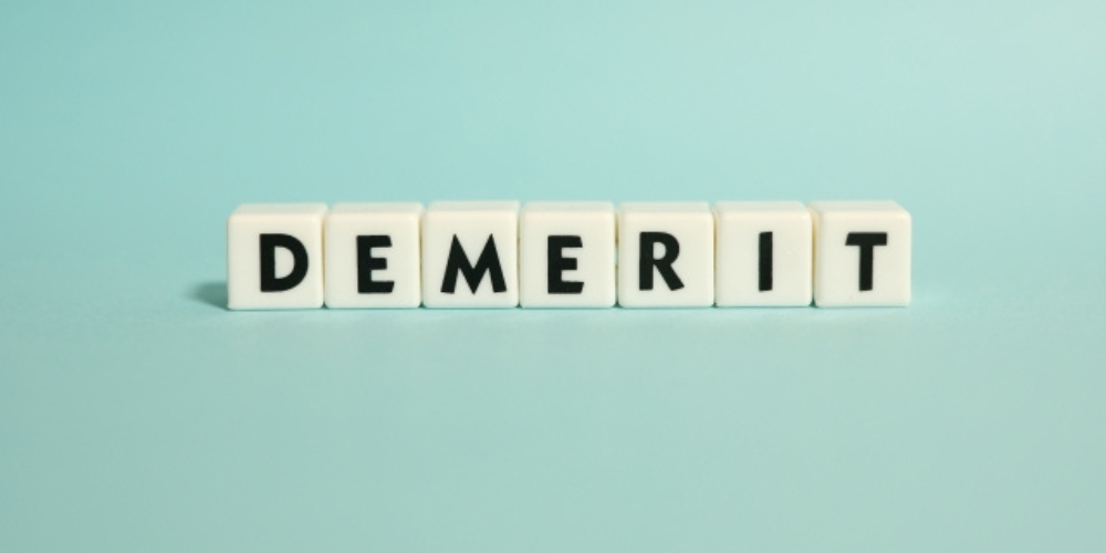 水色の背景の上に白いキューブ型のブロックで「DEMERIT」と並べられている