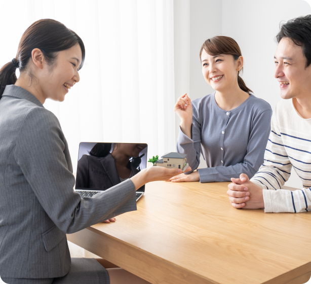 笑顔の男性と女性に、笑顔で説明する女性スタッフの様子。