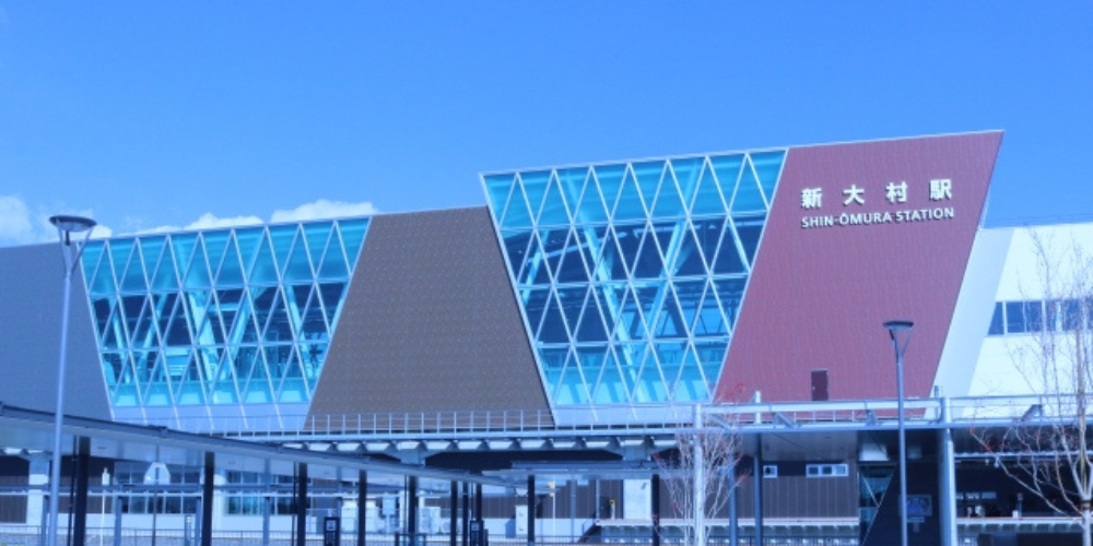 青空の下にある現代的なデザインの新大村駅の外観