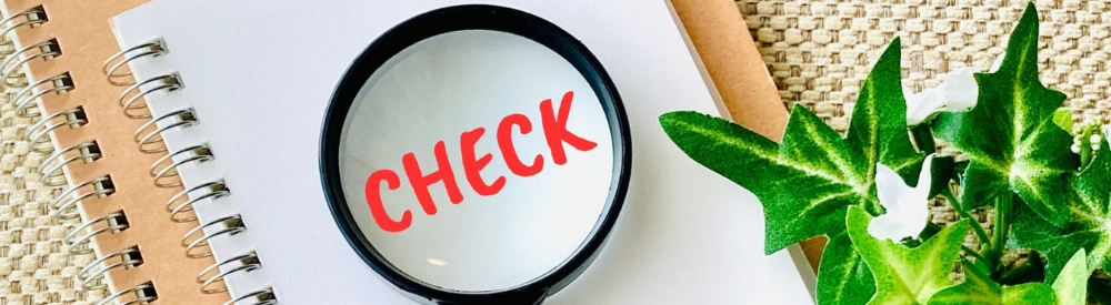 虫眼鏡で「CHECK」という文字を拡大している様子