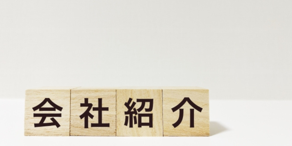 木製ブロックに「会社紹介」と書かれたシンプルで明るい背景の画像