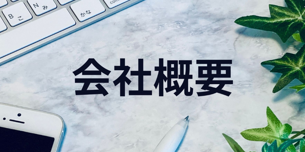 「会社概要」と書かれた文字とキーボード、スマートフォンが置かれたデスク