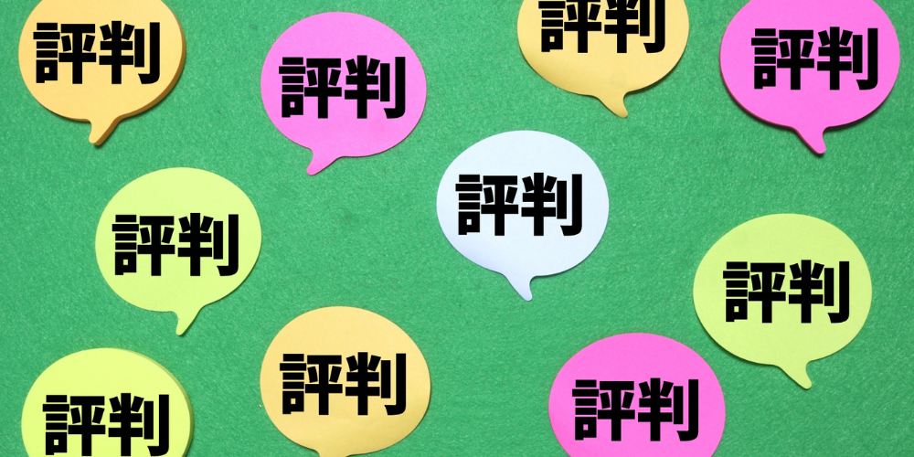 緑のフェルト調背景に色とりどりの吹き出しが散りばめられ、すべて黒文字で「評判」と記載されている