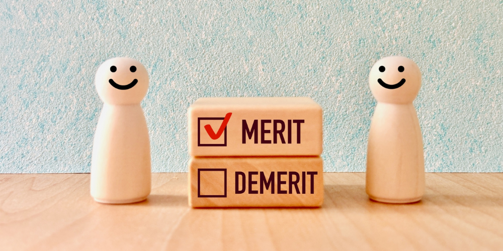 「MERIT」の項目にチェックが入った積み木と笑顔の木製人形