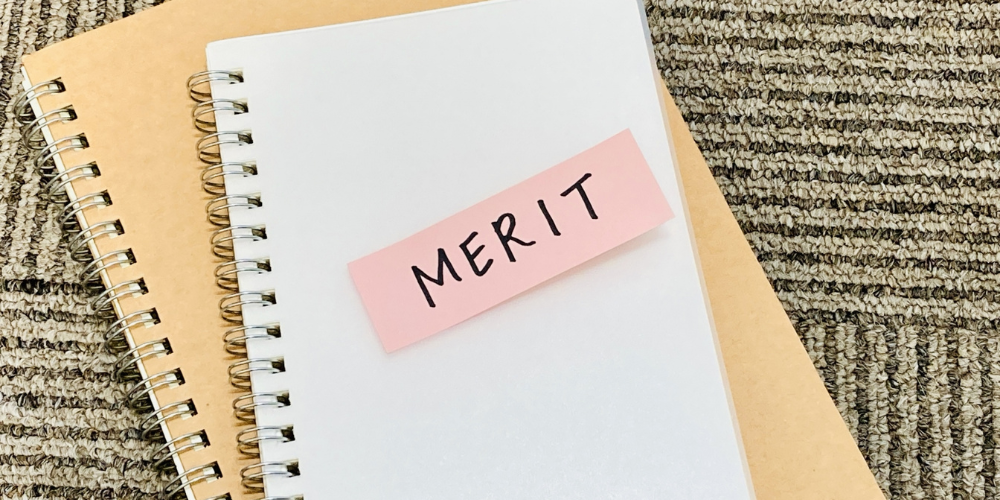 ノートに貼られた「MERIT」という文字の付箋