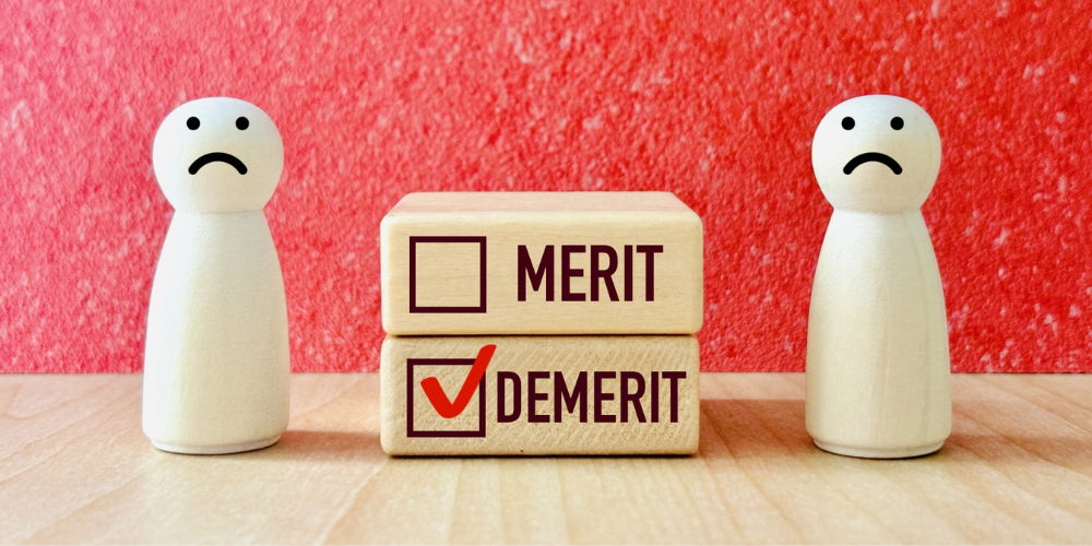 「DEMERIT」の項目にチェックが入った積み木と悲しい顔の木製人形