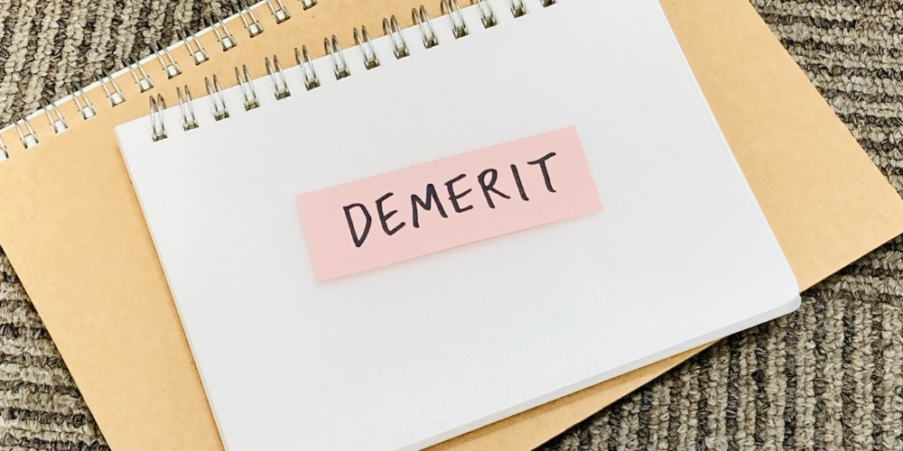 ノートに貼られた「DEMERIT」という文字の付箋