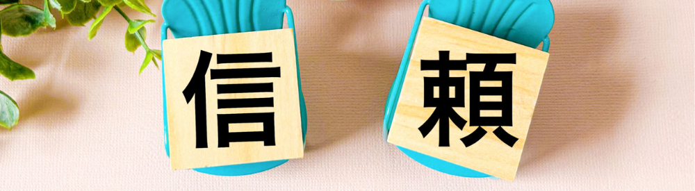 「信頼」という漢字が書かれた2つの木製プレート