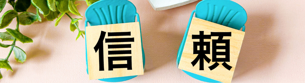 「信頼」という漢字が書かれた2つの木製プレート