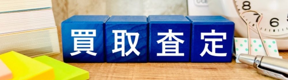 青いブロックに「買取査定」と書かれた文字、時計やペン、付箋が並ぶ査定イメージ