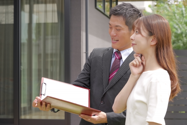戸建て住宅を見学している女性と営業マン